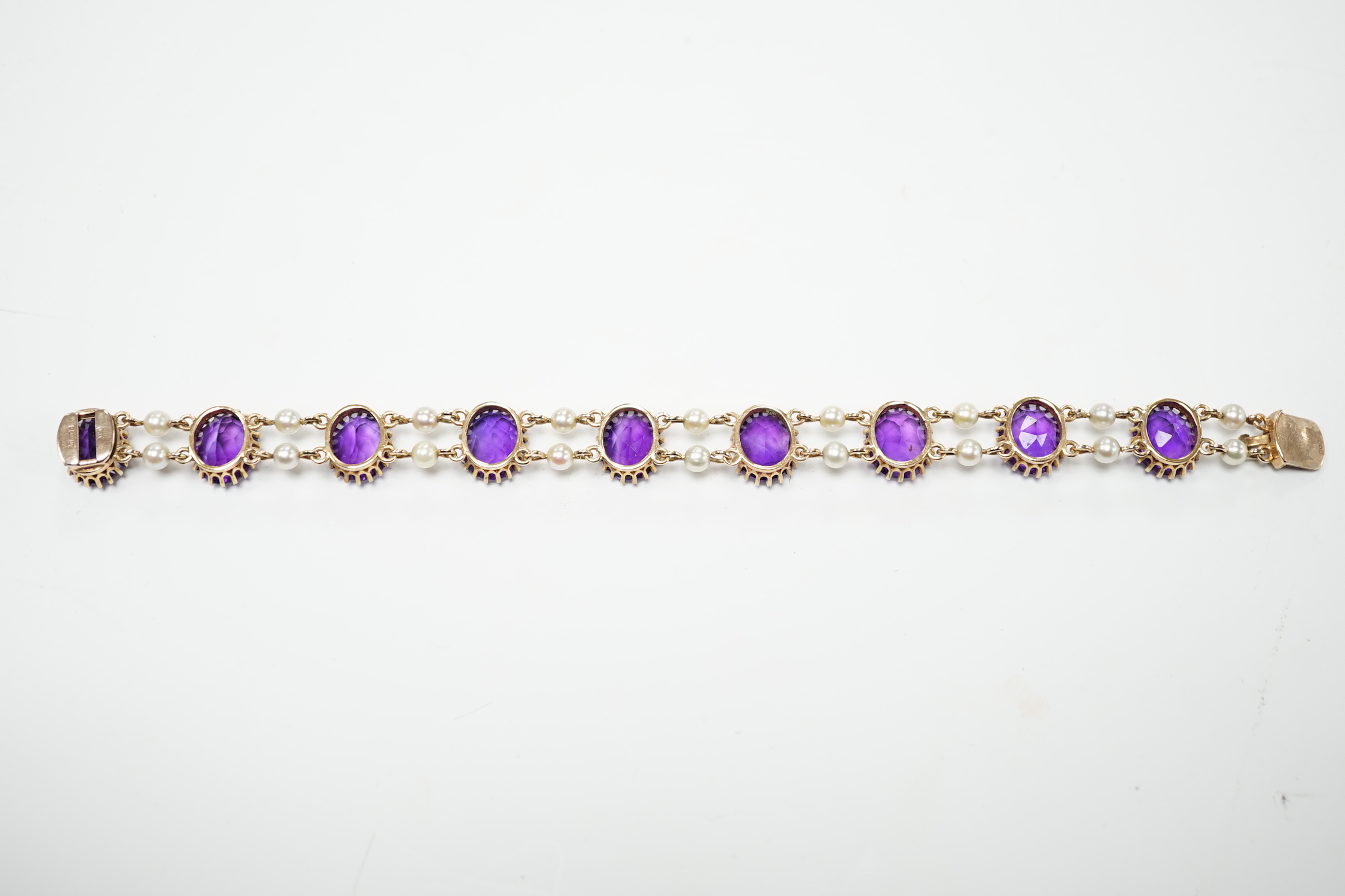 A 1970's Edwardian style 9ct gold amethyst and cultured pearl cluster set bracelet, 17.5cm, gross weight 15.9 grams.